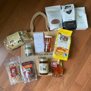 Porch Package includes horse pasta, candle, chocolate bar, honey, pancake mix, nuts, granola, fudge, maple syrup. Choice of hot chocolate, coffee or tea. Free tote bag. All local products
