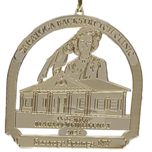 brass ornament celebrating the backstretch clinic-dedicated to Mary Lou Whitney