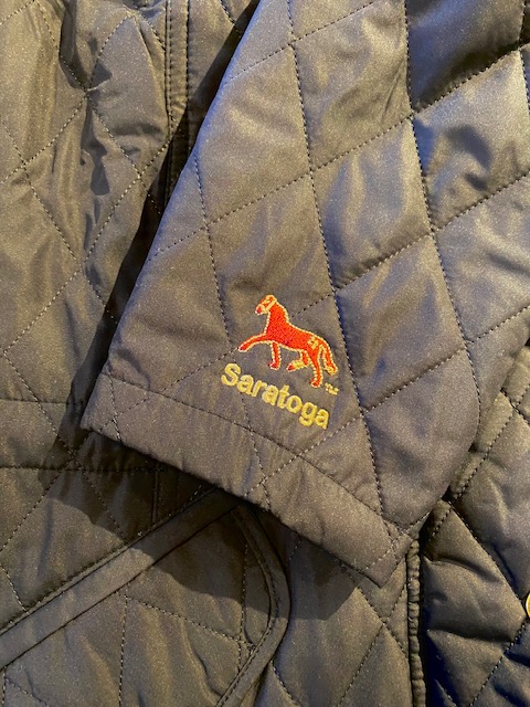 Barbour quilted jacket sleeve featuring a horse and "Saratoga"