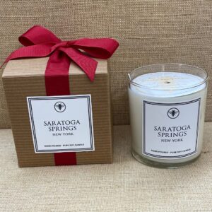 Brown box with red colored ribbon for candle- candle has white label with Saratoga Springs New York